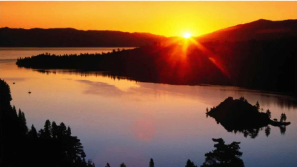 The sun setting over Emerald Bay with Fannette Island in silhouette on the water