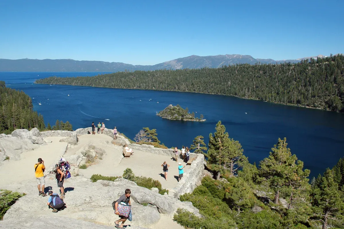 Visitors on the granite lookout terrace above Emerald Bay with Fannette Island in the blue water below